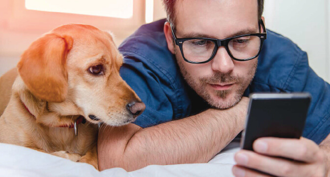 Man looking at phone with his dog