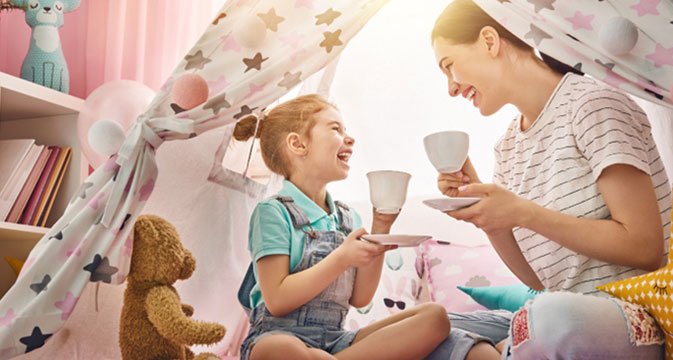 Mother and daughter having a tea party